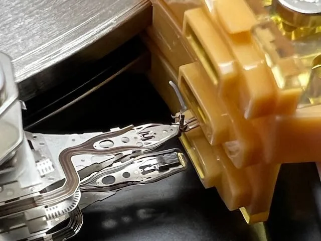 Makro snímek čtecí hlavy pevného disku v přípravku